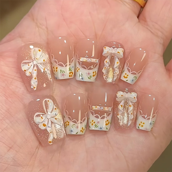Artful Nail Extensions with Floral Design and Bow Accents Stornfield