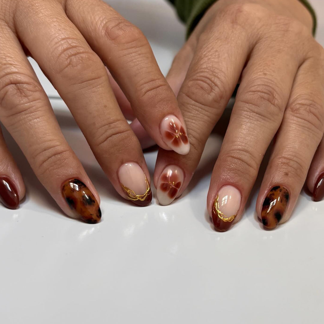 Artful acrylic nails with floral embellishments and glitter accents Stornfield