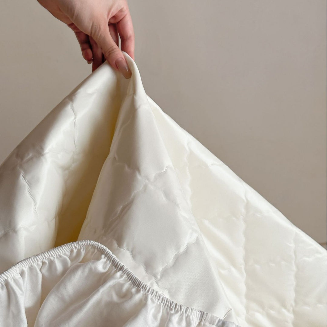 Padded quilted mattress topper with non-slip bottom and breathable fiber filling