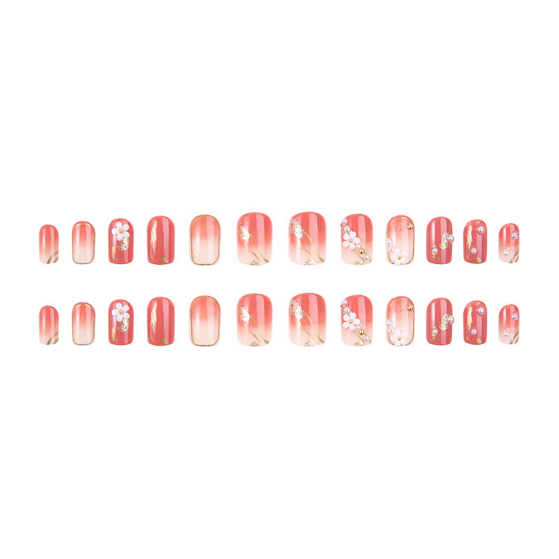 Acrylic nail set with elegant floral decorations and glamorous pearl accents Stornfield