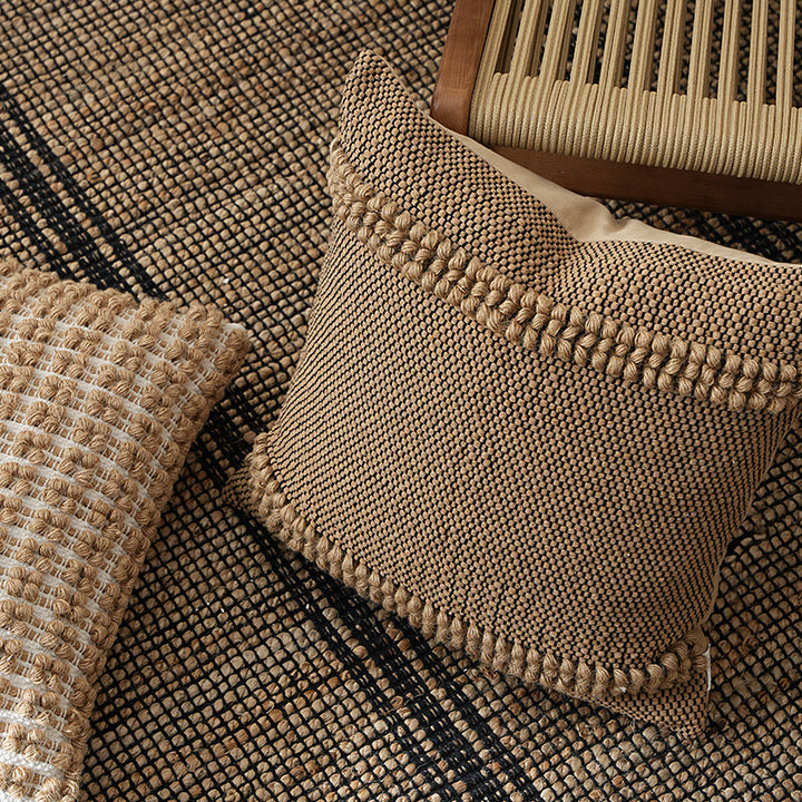 Square Boho decorative cushion made of coarsely woven cotton blend with decorative cord tufts