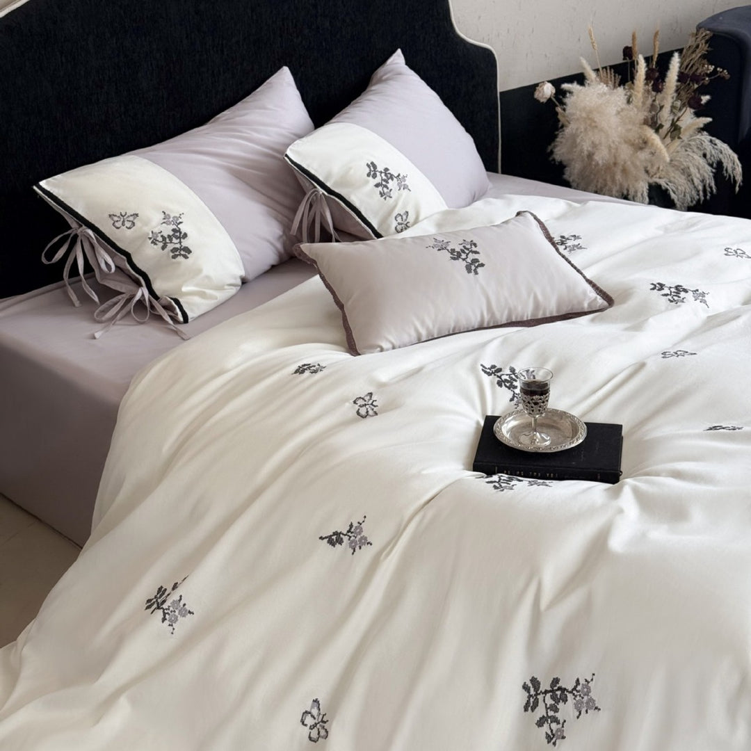 Luxurious satin bedding set with embroidered flower pattern and decorative pillow