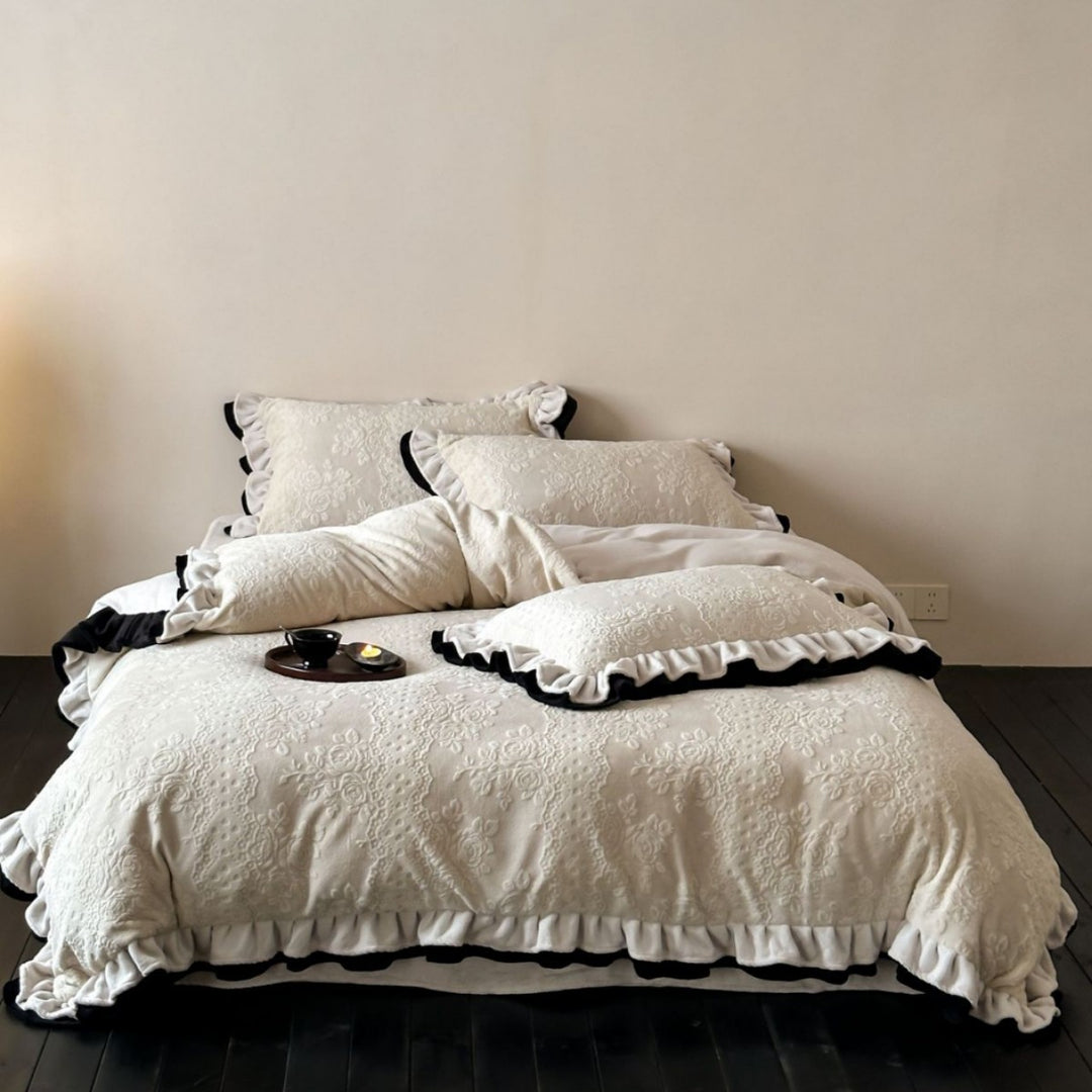 Quilted bedding set with floral embossing and ruffled frills
