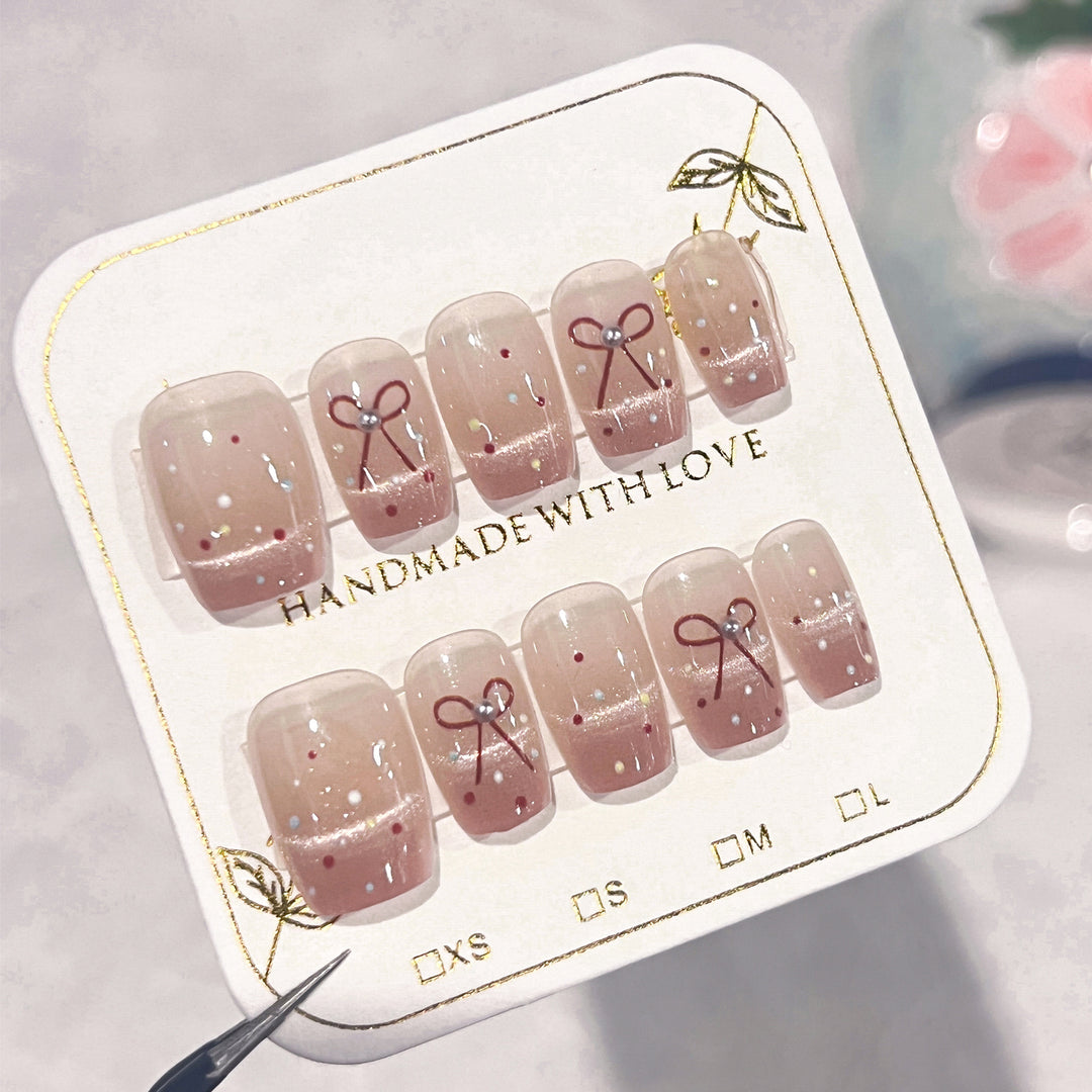 Artificial nail art with elegant bows and glitter accents Stornfield