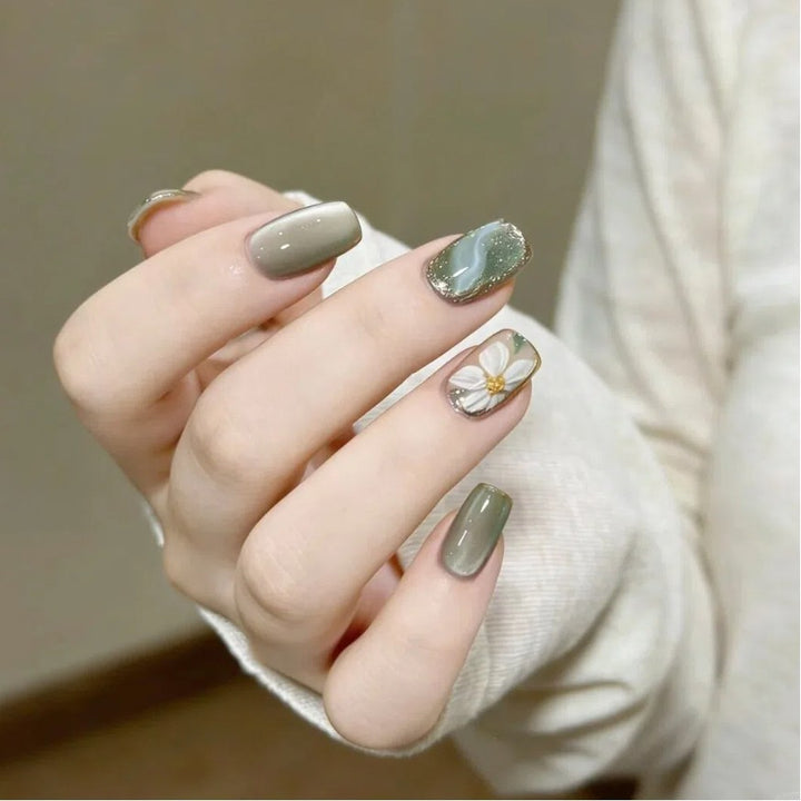 Artificial nails with floral accents and glamorous gold trim Stornfield