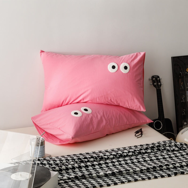 Playful cushion cover set with embroidered eye appliqués made of soft cotton fabric