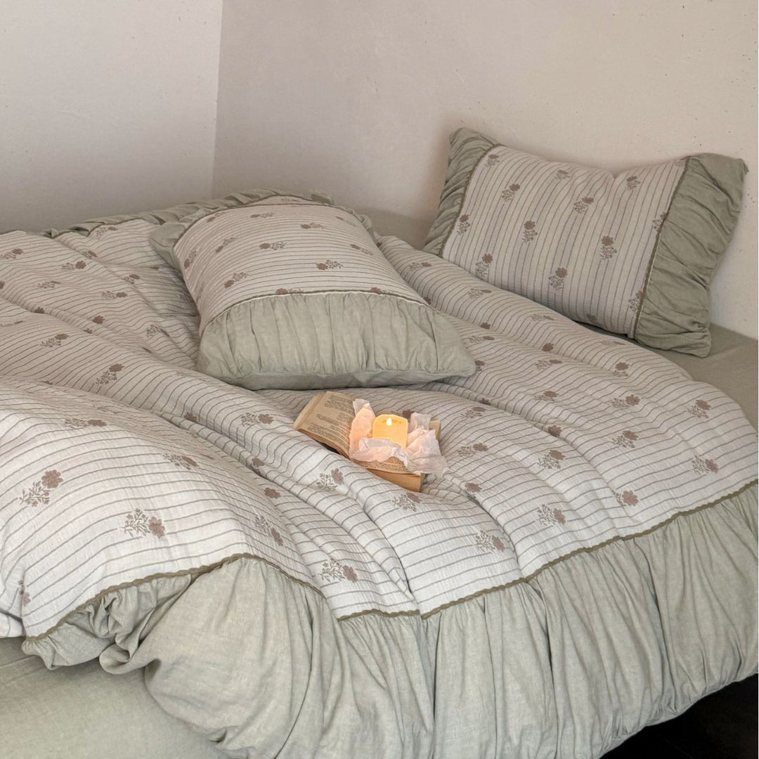 Padded bedding set with ruffled border, quilted bedspread and fine floral pattern