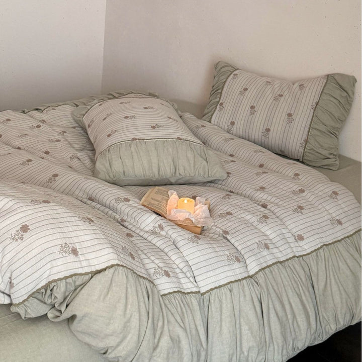 Padded bedding set with ruffled border, quilted bedspread and fine floral pattern