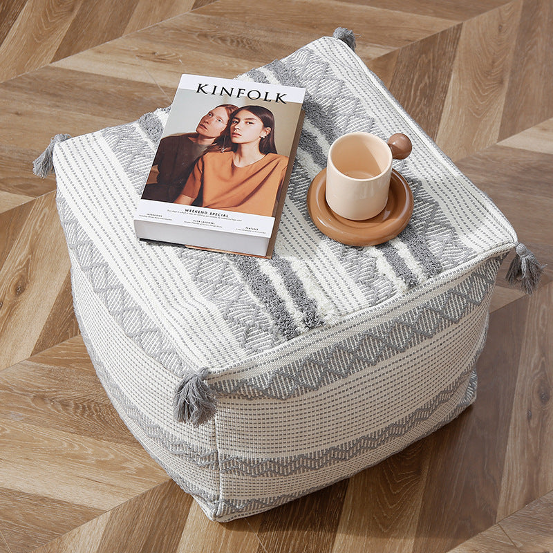 Braided square floor seat pouf with tassels and woven ethnic pattern
