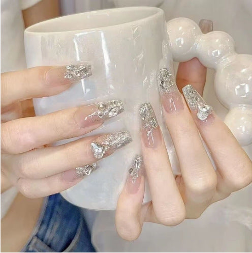 Artistic Nail Art with Glitter and Flower Applications Stornfield