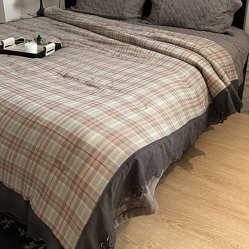 Quilted bedspread with lace trim and vintage stripe pattern