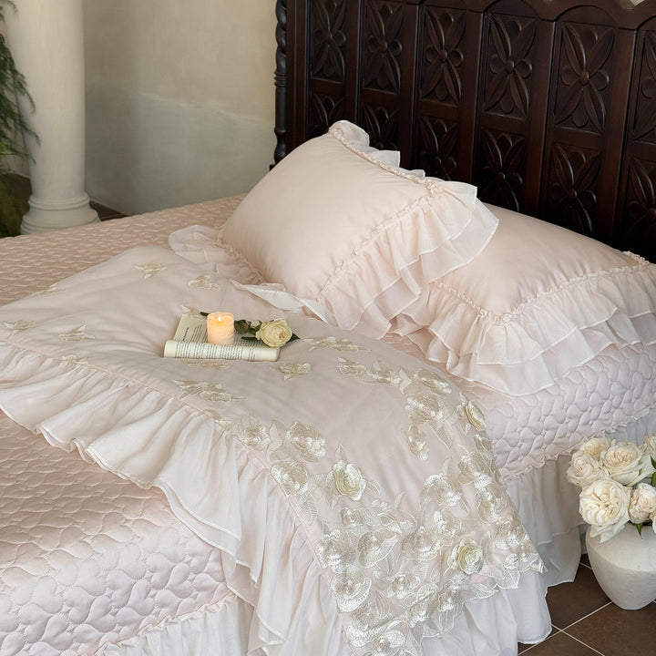 Romantic bedding set with quilted bedspread, ruffled pillow and floral embroidery