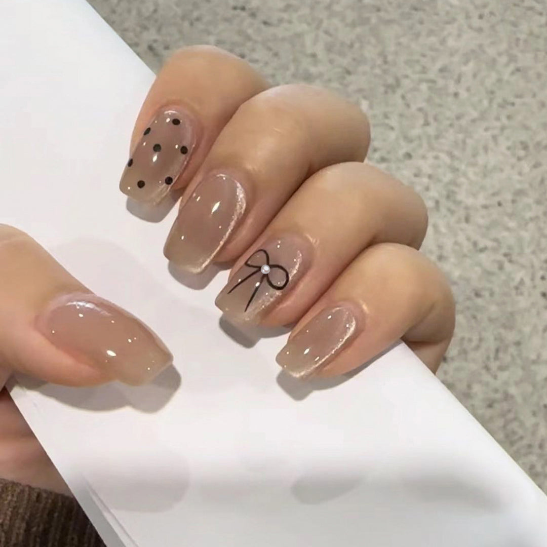 Artificial nail extensions with decorative bows and dots Stornfield
