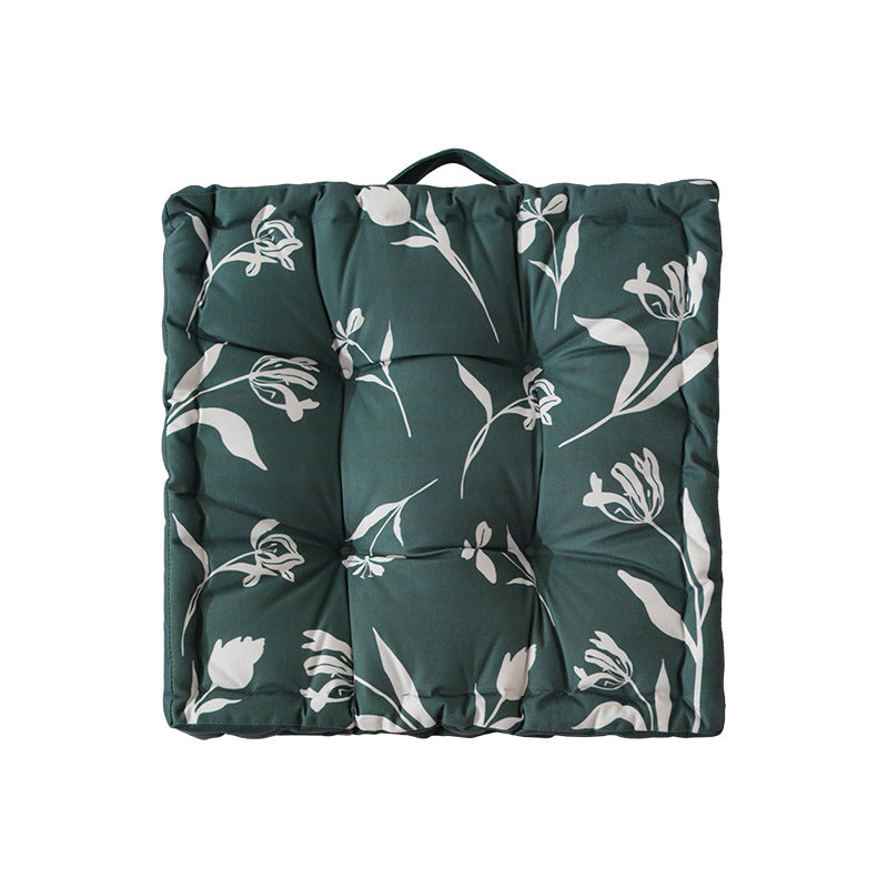 Padded floor cushion with quilted tufting, floral motif and carrying handle