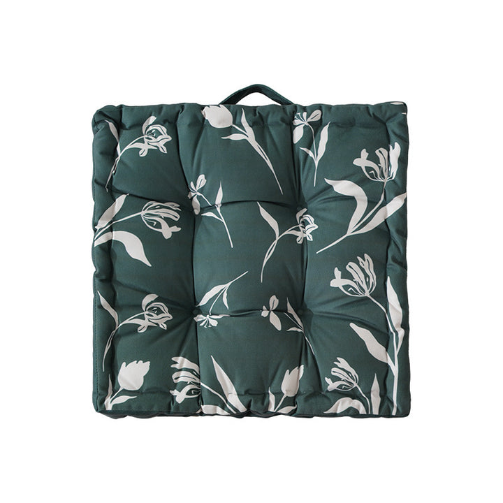 Padded floor cushion with quilted tufting, floral motif and carrying handle