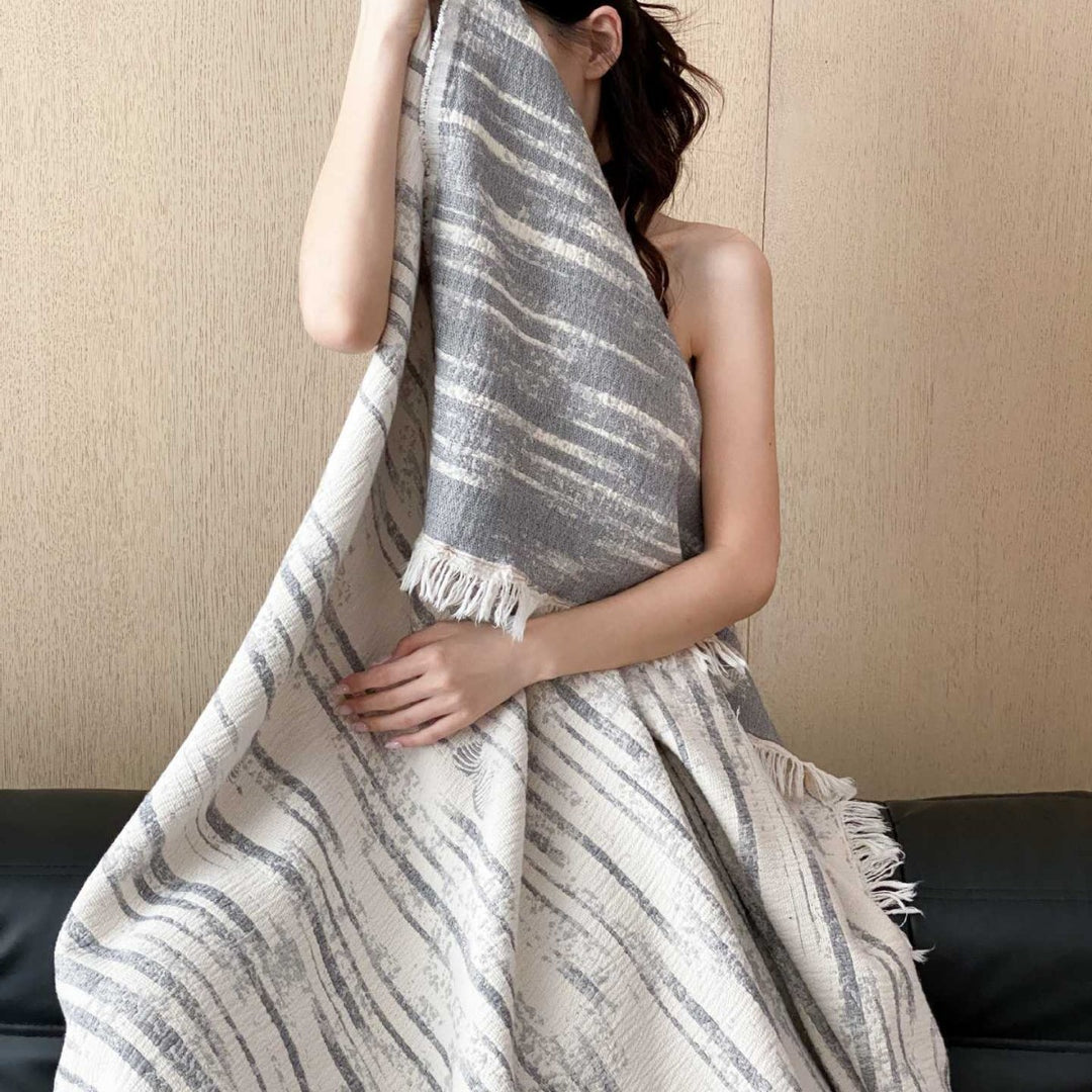 Cozy living blanket made of cotton blend fabric with fringes and striped texture