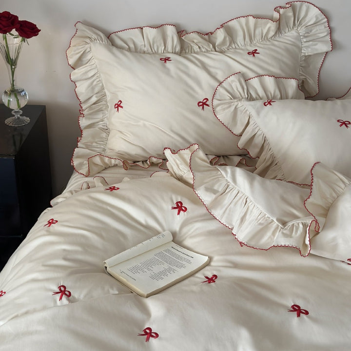 Ruffled bedding set with embroidered bows and frills