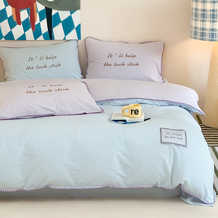 Striped cotton bedding set with subtle slogan appliqués and decorative piping