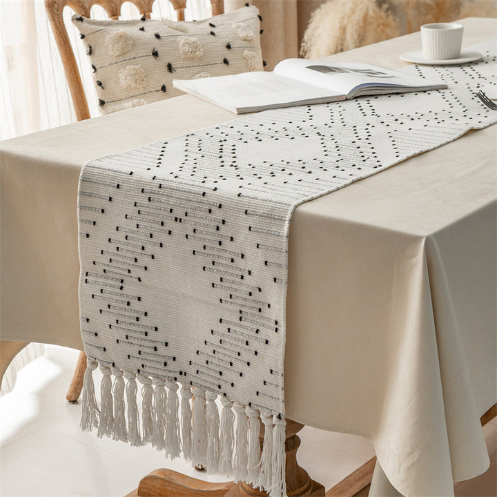 Woven table runner with geometric polka dot pattern, hand-fringed edge and sturdy cotton blend