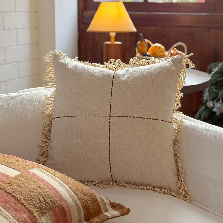 Decorative cushion made of linen look with hand-tied fringes and cross-stitch detail