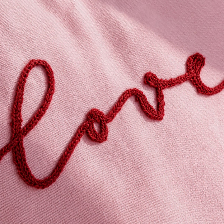 Heart-shaped decorative pillow with ruffled trim and embroidered inscription Stornfield