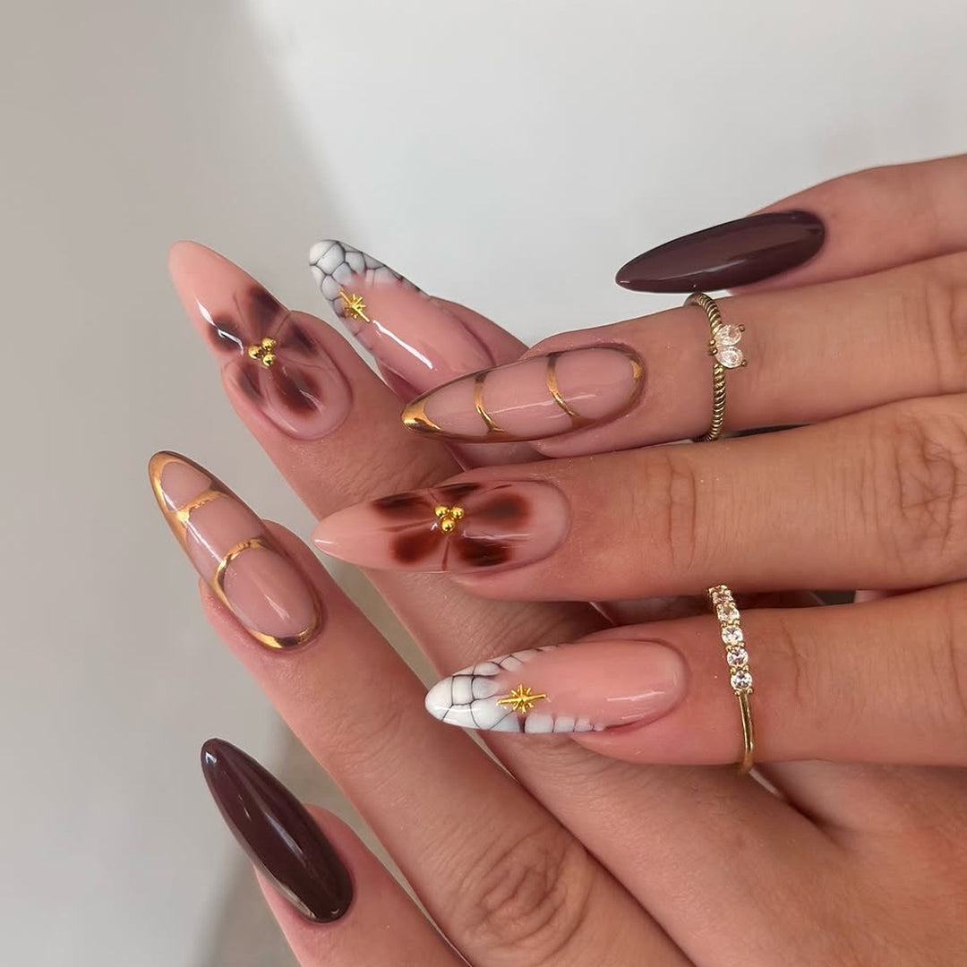 Artful Stiletto nails with gold accents and decorative floral designs Stornfield