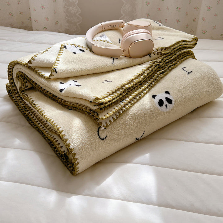 Microfleece cuddly blanket with polka dot pattern and decorative overlock seam