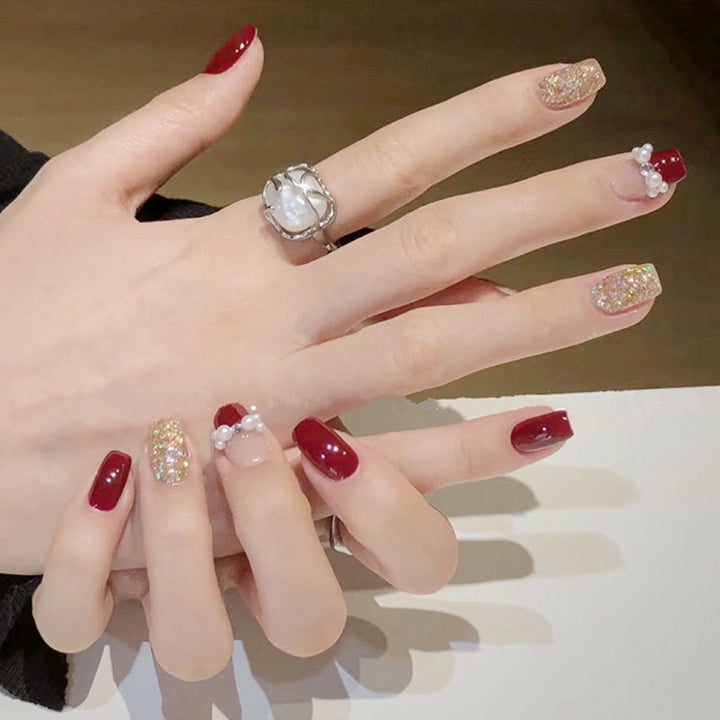 Glamorous artificial nails with glitter and pearl decorations Stornfield