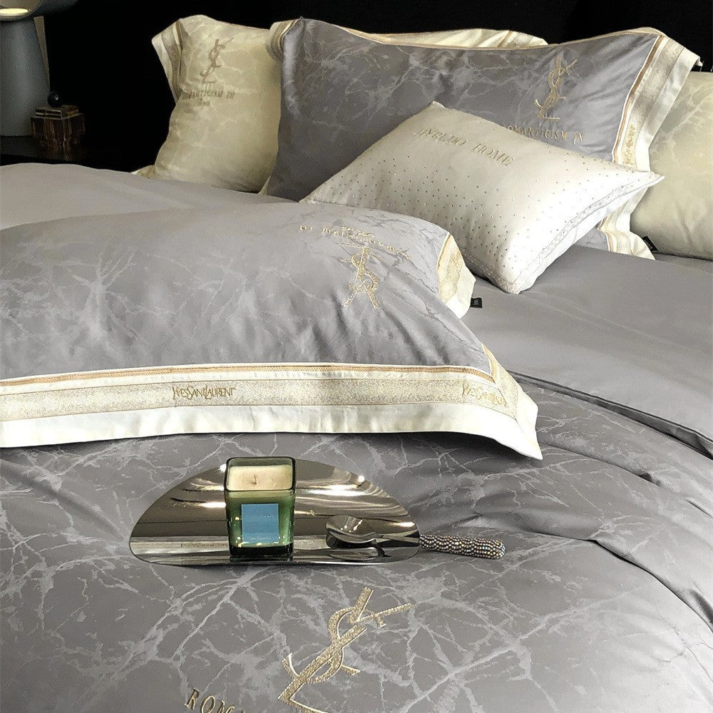 Luxurious satin bedding set with subtle marble texture and golden embroidered border