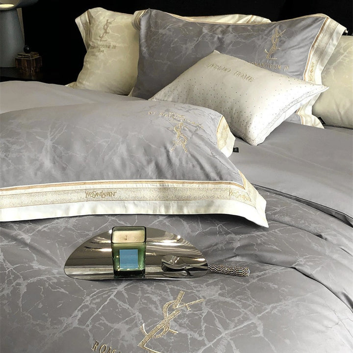 Luxurious satin bedding set with subtle marble texture and golden embroidered border