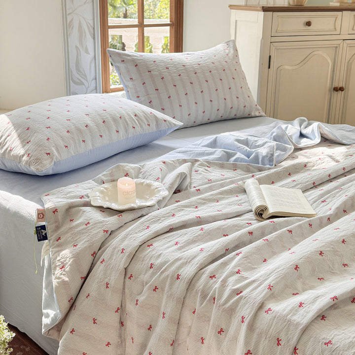 Quilt set in quilted cotton muslin with reversible function, delicate floral print and matching fitted sheet