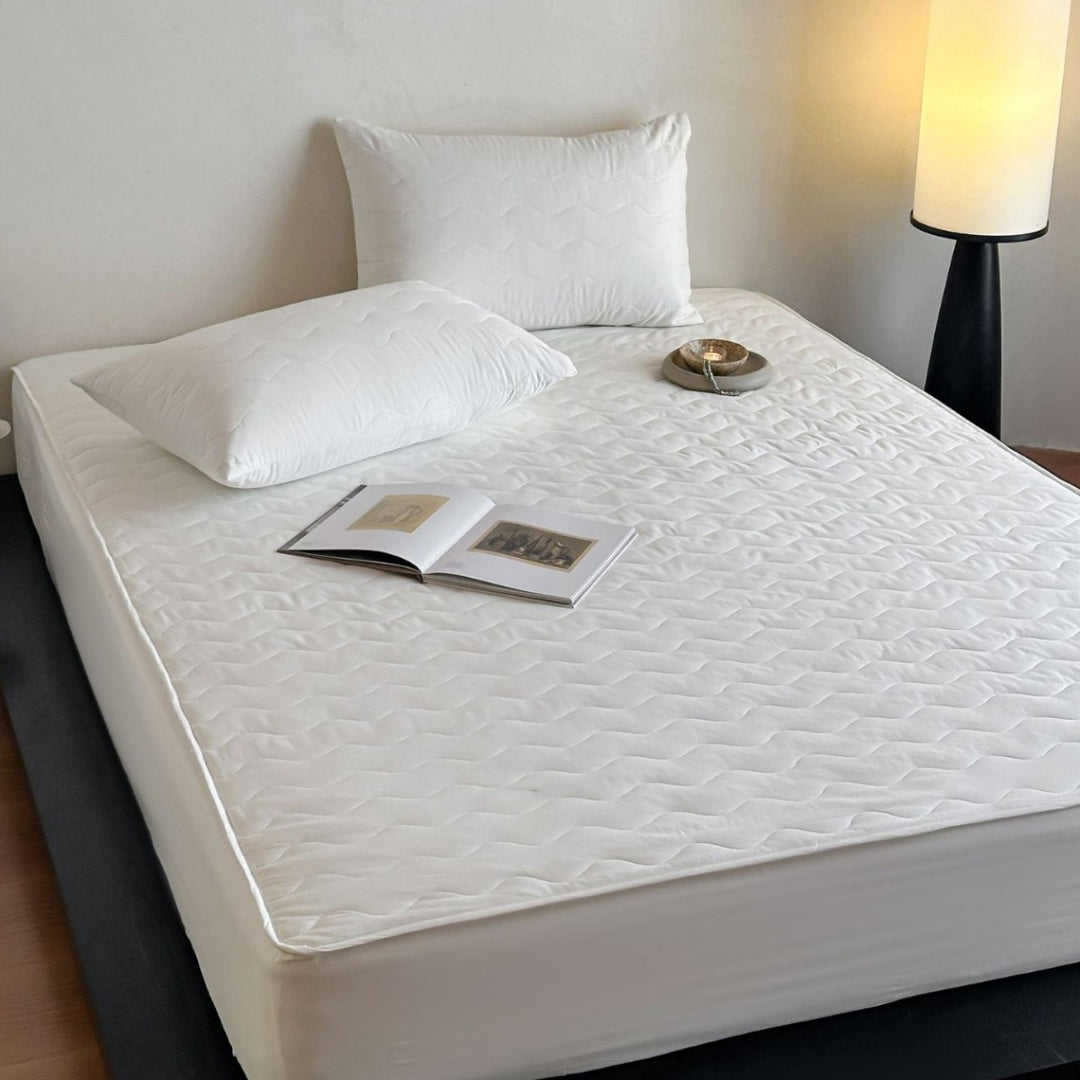 Padded mattress protector with all-round stretch and quilting
