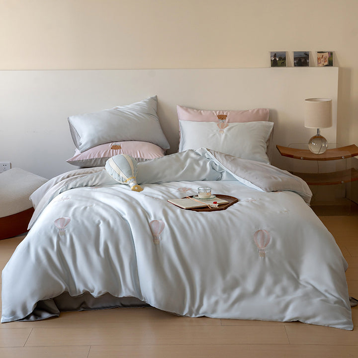 Bedding set with embroidered hot air balloon motifs and silky satin finish