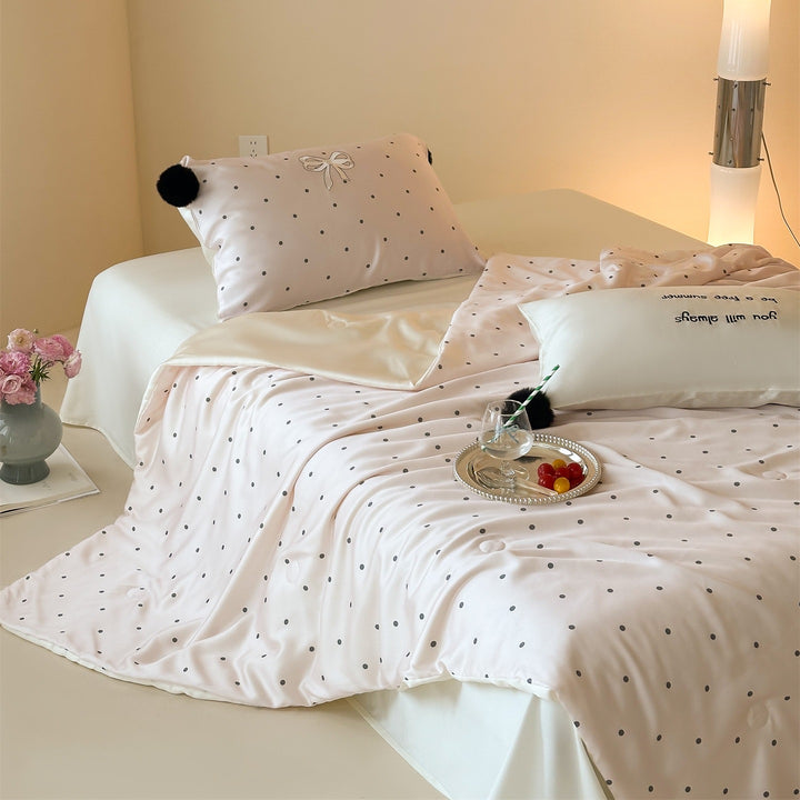 Luxurious satin bedding set with polka dot pattern and pom-pom tassels