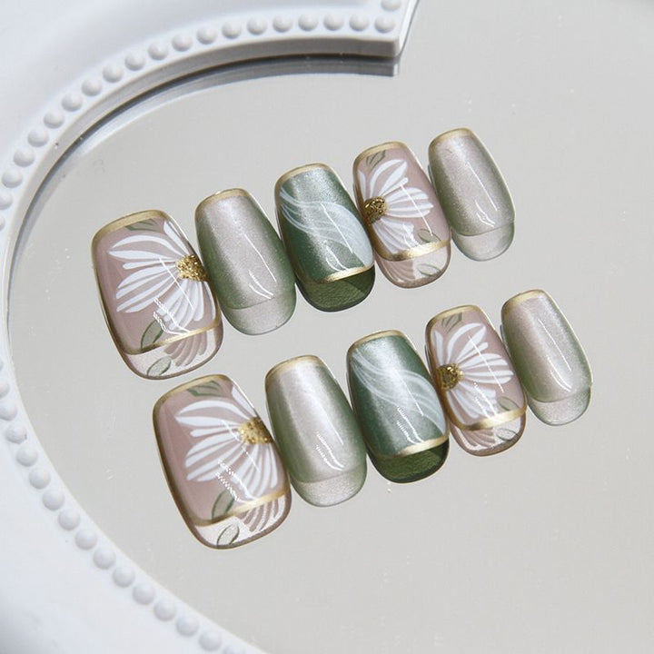 Artificial nails with floral accents and glamorous gold trim Stornfield
