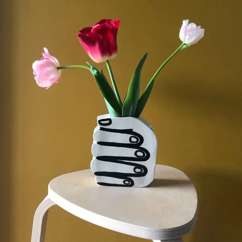 Hand holding a vase of flowers | Stornfield