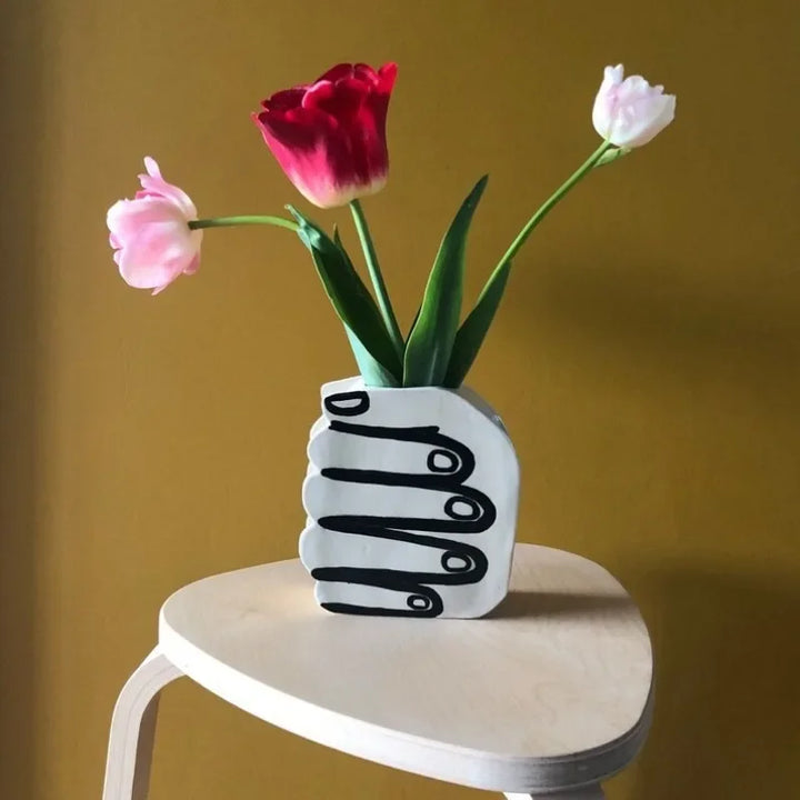 Hand holding a vase of flowers | Stornfield