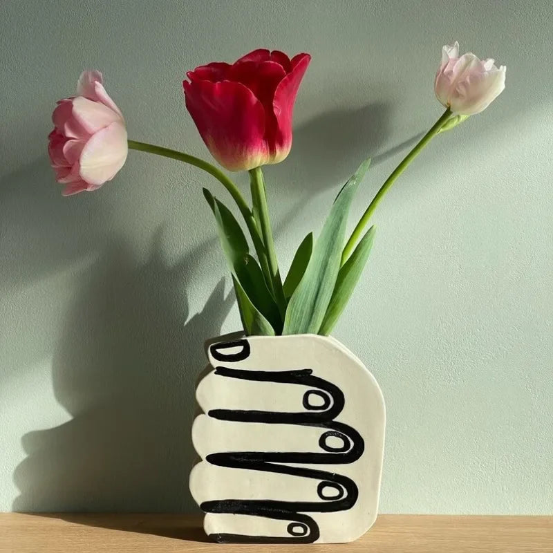 Hand holding a vase of flowers | Stornfield