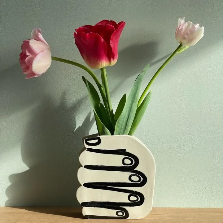 Hand holding a vase of flowers | Stornfield