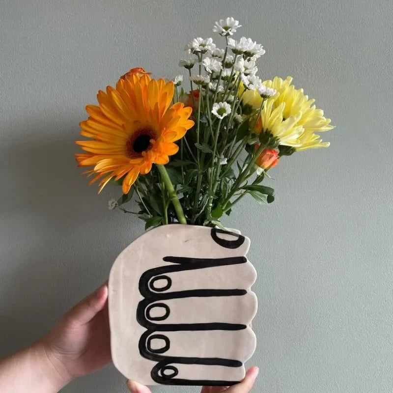 Hand holding a vase of flowers | Stornfield